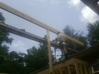 Carpenter setting a ridge beam over a new addition frame — Ice Dam Removal by Roofing Brothers in White Post