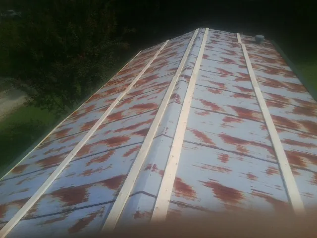 Rusted metal roof panels with new wood purlins before replacement — Storm Damage Roof Repair in White Post by Roofing Brothers