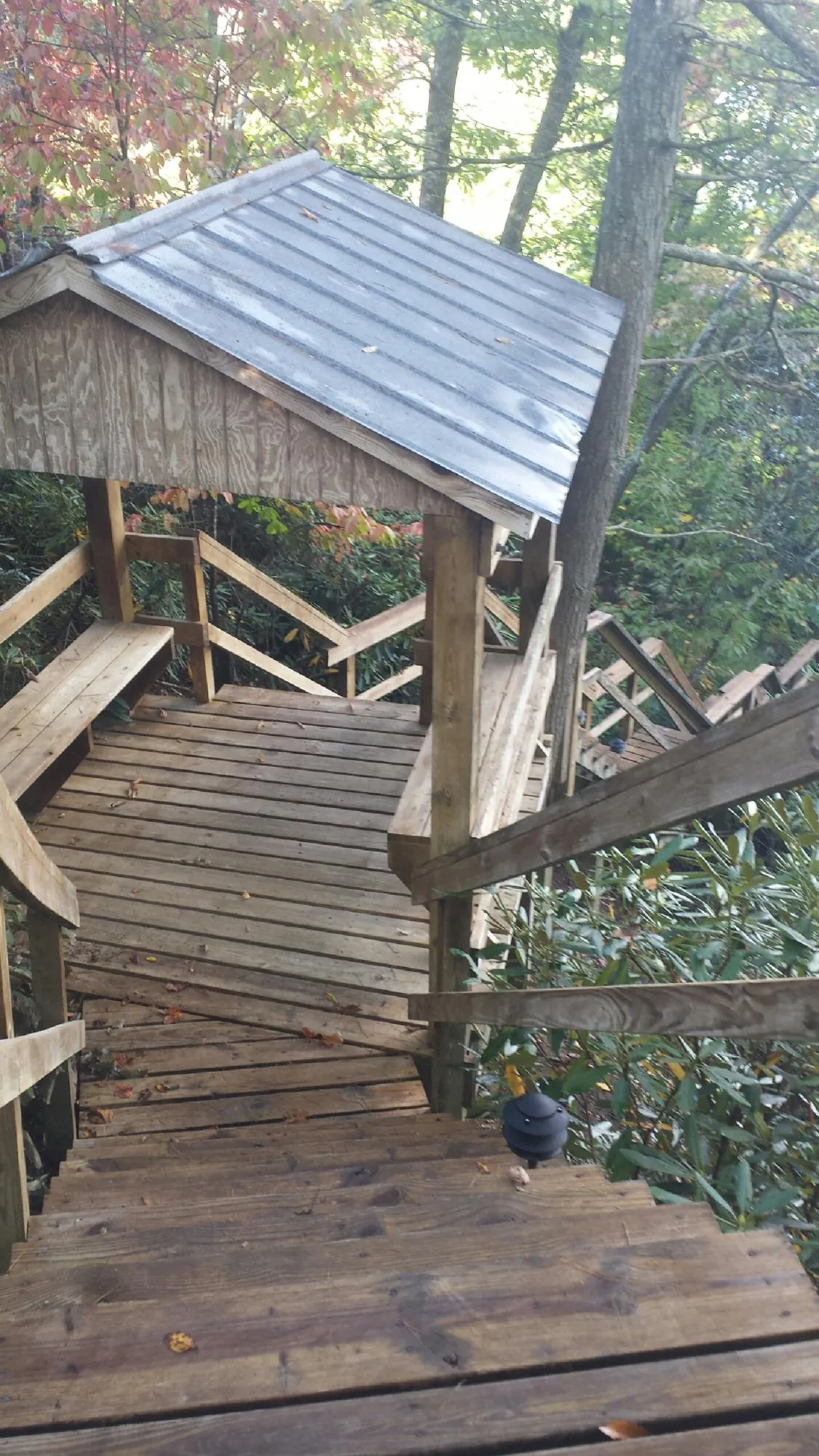 Metal roofed shelter over wooden steps on a wooded walkway — Skylight Repair & Installation work by our crew in White Post