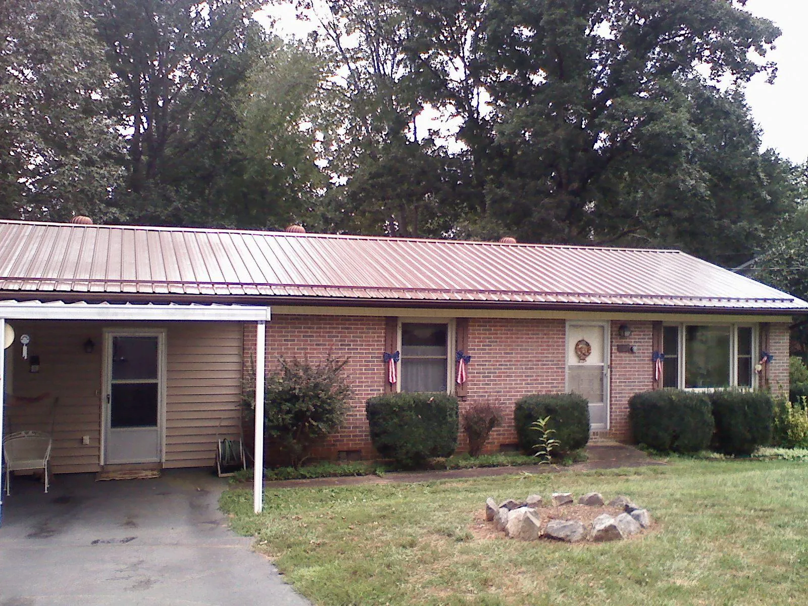Bronze metal roof and carport on a brick ranch home — Roof Repair work by our crew in White Post